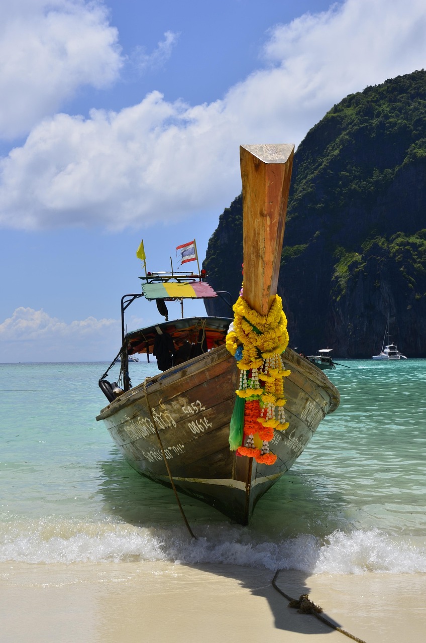 Longtail boat moored on a Krabi beach under cliffs
